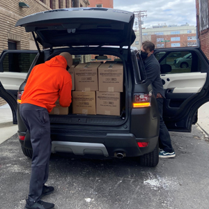 Man putting boxes of food into back of car